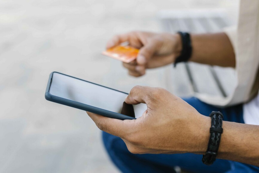 Konsum im Wandel: Mann kauft über sein Smartphone mit der Kreditkarte ein.