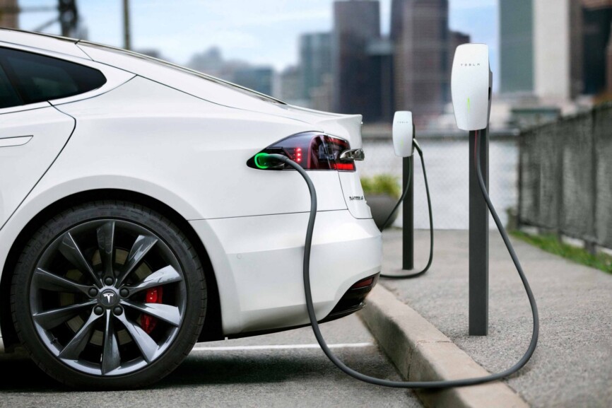 Ein weißer Tesla lädt vor der Weiterfahrt noch einmal seine Batterie.