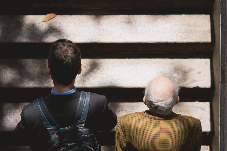 Mann aus der Gen Z und alter Mann laufen eine Treppe hinauf