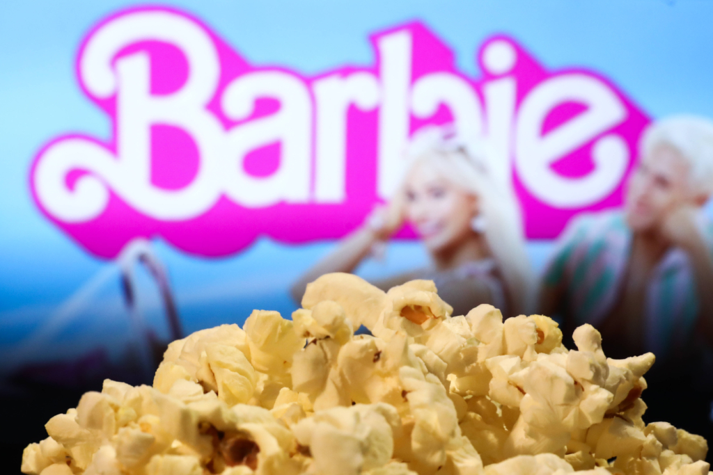 Mattel Movies Photo Illustrations A popcorn and Barbie movie website displayed on a screen in the background are seen in