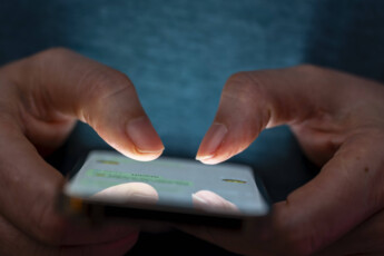 27.02.2025, Thema Smartphone-Nutzung, Frau tippt auf einem Apple iPhone13 Smartphone-Screen SMS. Das Bild zeigt eine Person, die in einer schlecht beleuchteten Umgebung ein Smartphone benutzt. Die Beleuchtung hebt die Finger des Benutzers und den Bildschirm des Smartphones hervor. 27.02.2025, Smartphone 27.02.2025, Smartphone *** 27 02 2025, Smartphone use theme, woman typing on an Apple iPhone13 Smartphone Screen SMS The image shows a person using a smartphone in a poorly lit environment The lighting highlights the users fingers and the smartphone screen 27 02 2025, Smartphone 27 02 2025, Smartphone