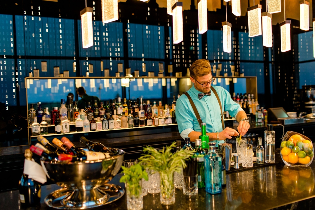 Während die Hotelkette auf einige Dinge wie Zimmerservice, Telefone und Schränke verzichtet, gehört eine nette Bar wie hier in München zur Ausstattung jedes Hauses. (© Motel One)