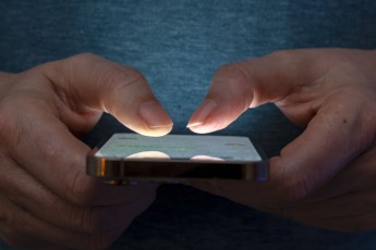 27.02.2025, Thema Smartphone-Nutzung, Frau tippt auf einem Apple iPhone13 Smartphone-Screen SMS. Das Bild zeigt eine Person, die in einer schlecht beleuchteten Umgebung ein Smartphone benutzt. Die Beleuchtung hebt die Finger des Benutzers und den Bildschirm des Smartphones hervor. 27.02.2025, Smartphone 27.02.2025, Smartphone *** 27 02 2025, Smartphone use theme, woman typing on an Apple iPhone13 Smartphone Screen SMS The image shows a person using a smartphone in a poorly lit environment The lighting highlights the users fingers and the smartphone screen 27 02 2025, Smartphone 27 02 2025, Smartphone