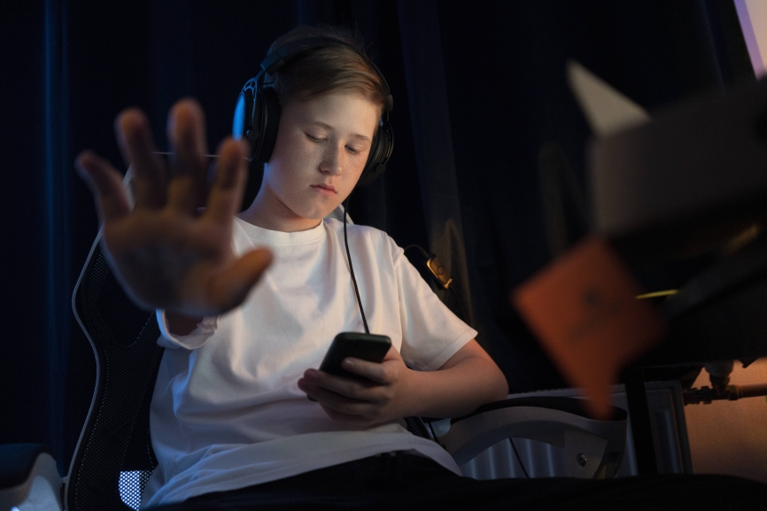 Boy showing stop sign while using smart phone at home model released Symbolfoto property released VPIF04637