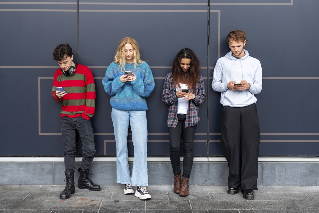 People using mobile phones outdoors in urban setting with digital addiction model released, Symbolfoto, WPEF10131