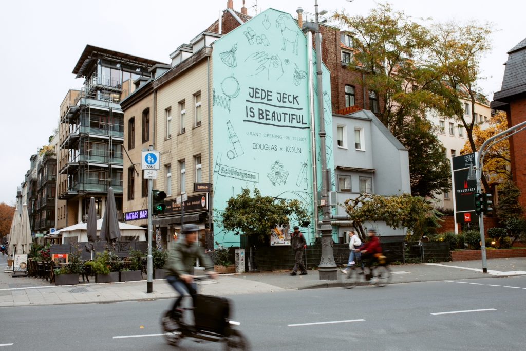 Aufmerksamkeitsstarkes Wandbild: Die Bildsprache des Kölner Street-Art-Künstlers Pusher Tony verbindet Stadtidentität und Beauty-Ästhetik.